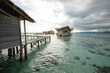 © Yevhenii - Pier leading to wooden overwater bungalows that sit above crystal clear blue water, vacation on the tropical island