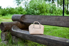 Ladies Hand Beige Bag On A Bench Outside. Forgotten Things In A City Park