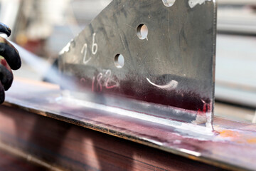 The inspector is applying the developer to test area. for penetrant testing. Several developer types are available, including: non-aqueous wet developer, dry powder and water-suspendable.