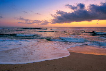 dawn at the beach of a black sea. gorgeous sky above the water surface. tide washing the shore