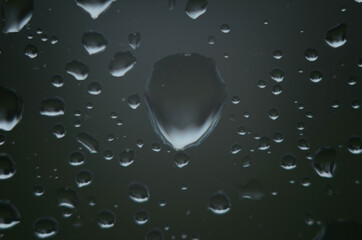 Rain drops on window glasses surface with cloudy background . Natural Pattern of raindrops on cloudy background.