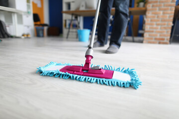 Wall Mural - Man in office mops floor. Services of cleaning companies concept