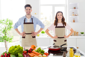 Wall Mural - Portrait of positive friendship spouses put hands waist confident ready cook tasty delicious meal lunch dish in kitchen house indoors