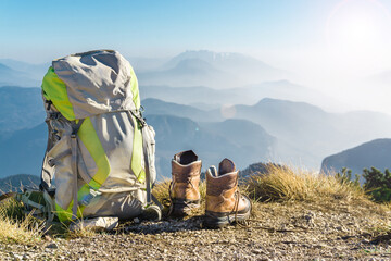 Hiking equipment. Backpack and boots on top of mountain Corno di Tres, Tresner Horn, Trentino, South Tyrol, Val di Non, Val d'Adige, Alps, Italy.