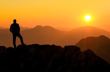 Poster - Happy success winning man standing relaxed on mountain at sunset. Border region of Tyrol, Austria and Allgaeu, Bavaria, Germany.