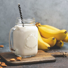 Wall Mural - Vegetarian vegan almond banana smoothie in glass jar. Healthy protein smoothie of banana