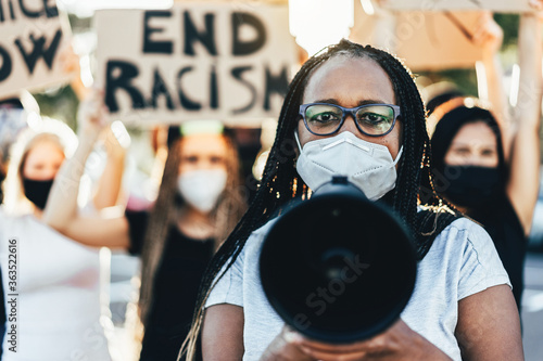 Plakat People from different ages and races protest on the street for equal rights - Demonstrators wearing face masks during black lives matter fight campaign - Focus on woman face