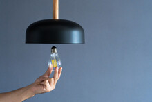 Close-up. A Hand Changes A Light Bulb In A Stylish Loft Lamp. Spiral Filament Lamp. Modern Interior Decor.