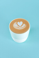 Wall Mural - Blue cup of latte art with copy space. Hot fresh milk with latte in cup on bluebackground