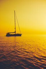 Wall Mural - Silhouette of a sailing boat in sunset / sunrise time and ocean horizon.