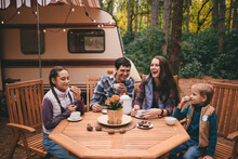 Happy Family On A Camping Trip Relaxing In The Autumn Forest. Camper Trailer. Fall Season Outdoors Trip