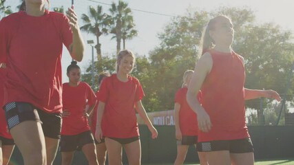 Wall Mural - Female soccer team warming up during training before match against flaring sun - shot in slow motion