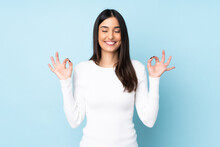 Young Caucasian Woman Isolated On Blue Background In Zen Pose