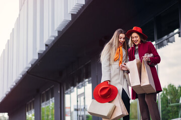 Young girlfriends with shopping bags are shopping at mall.