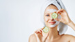 © Olesia - Cosmetology, skin care, face treatment, spa and natural beauty concept. Woman with facial mask holds slices of cucumber.