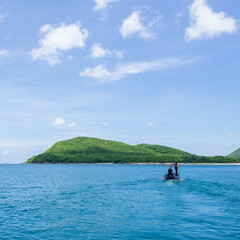 A small boat sailing to the forest island.