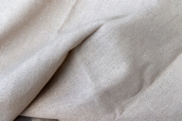 Natural beige linen fabric texture. Rough crumpled burlap background. Selective focus. Closeup view