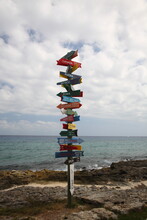 A Scenic View Of Direction Sign With Rocks And Ocean Under Blue Sky In Xcaret, Playa Del Carmen Mexico