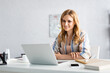 © LIGHTFIELD STUDIOS - Selective focus of attractive freelancer working with laptop