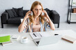© LIGHTFIELD STUDIOS - Selective focus of attractive freelancer working with laptop and headphones