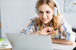 © LIGHTFIELD STUDIOS - Selective focus of beautiful adult freelancer working with laptop and headphones