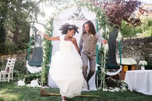 Bride And Groom Jumping Over A Broom