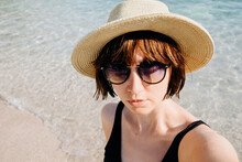 Shorthair Female Model With Hat And Sunglasses Taking A Selfie On The Beach