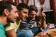 © MyMicrostock/Stocksy - Friends watching a soccer match at home