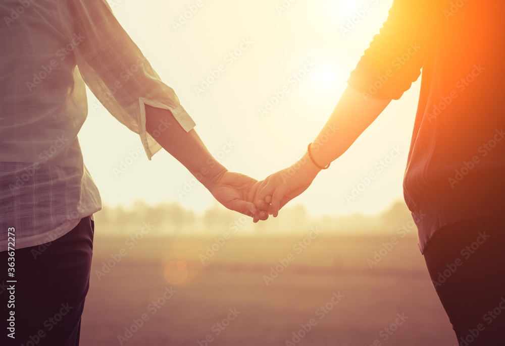 Midsection Of Couple Holding Hands Against Sky During Sunset - obrazy, fototapety, plakaty 