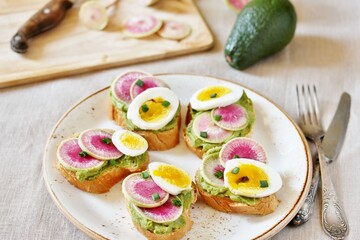 Wall Mural - watermelon radish sandwich with avocado and egg. healthy balanced breakfast. bright toast