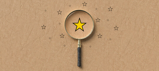 magnifying glass with a yellow star mark as symbol for finding a solution on paper background