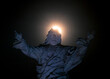 Full moon passing over a statue of Jesus in Honduras 