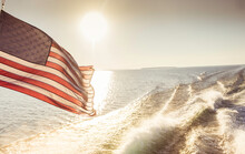 American Flag Waving In The Wind While On The Water