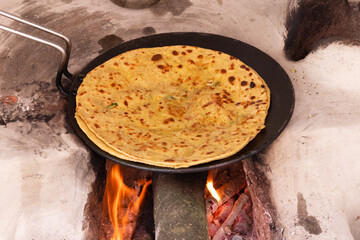 Aloo Paratha, cooking on traditinal wood fire stove (chulha), top side view