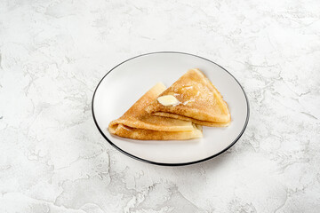 Two pancakes on a round, white plate. Close-up shot