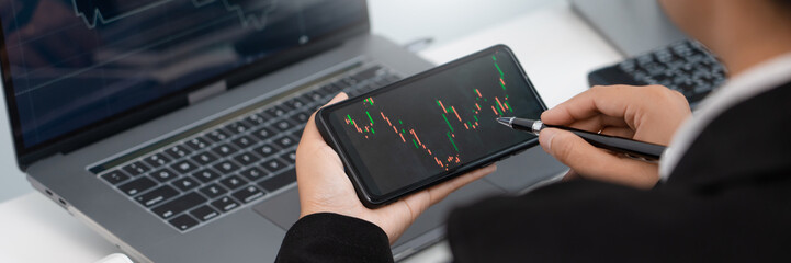 Stock market analysis successful broker or traders looking and focused talking about forex charts and data on multiple computer screens of stock market.