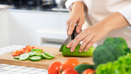 Wall Mural - Asian woman is preparing healthy food vegetable salad at light kitchen Cooking At Home and healthy food concept
