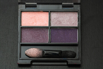 Wall Mural - Makeup eyeshadow palette close up isolated on black.