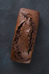 Wall Mural - Freshly baked homemade chocolate bread or cake on dark background, rustic style.