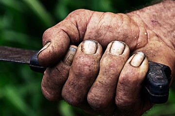 Canvas Print - Closeup shot of an old farmers dirty hand gripping a tool handle