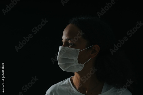 Low-key Image Of Woman Wearing A Surgical Mask