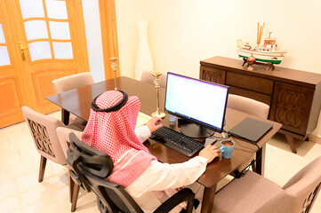 Wall Mural - Arabic man from Saudi Arabia working at home to protect him self from the viruses pandemic COVID-19 