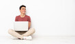 © luismolinero - Teenager man sitting on the flor with his laptop happy and smiling