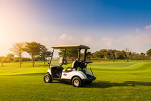 Golf Cart On Golf Course, Parking On Fairway. Equipment And Golf Club Bag Are Put In Ready For Golfer To Player In Field With Sunlight Rays Background