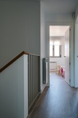 Poster - Vertical shot of a hallway leading to a room with white walls under the lights