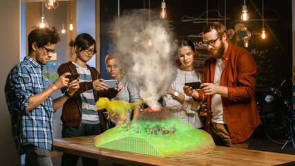 Wall Mural - group of young developers look at dinosaur and volcano eruption in augmented reality through smartph