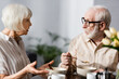 © LIGHTFIELD STUDIOS - Selective focus of elderly couple talking during breakfast at home