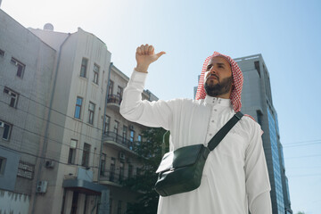 Rich arabian man's portrait during buying real estate, living house in city. Ethnicity, culture, diversity. Confident business man in traditional wear making a deal successful. Finance, economy.