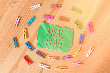 Word writing text Meal Plan. Business photo showcasing act of taking time to plan any number of meals for the week Colored clothespin papers empty reminder wooden floor background office