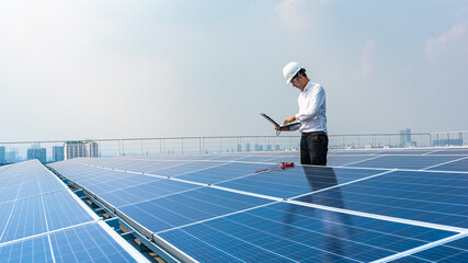 Electrical engineers are using laptops to monitor the operation of the solar rooftop. Renewable energy concepts.